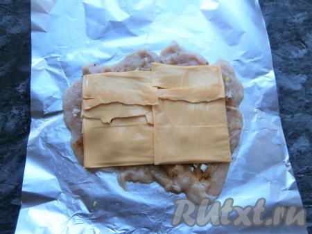 Сверху на мясо выложить пластины сыра.