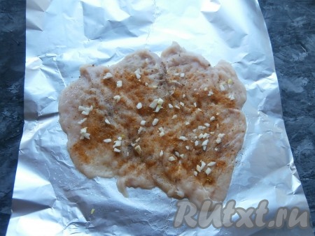 Посолить мясо, хорошенько натереть специями, поперчить. Чеснок мелко нарезать и распределить его по всему мясу.
