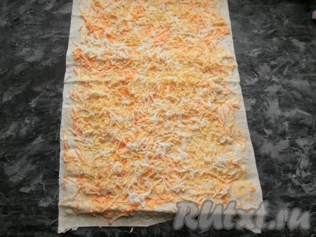 Куриные яйца сварить вкрутую (варим 8-10 минут с момента закипания). Яйца остудить и очистить. Натереть на средней тёрке яйца и сыр. Посыпать яйцами и сыром лист лаваша поверх морковной массы.
