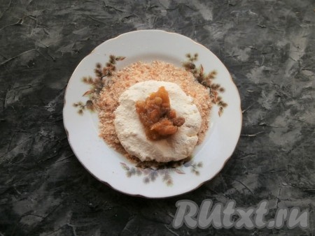 Из части творожного теста слепить лепёшку, в середину выложить 1 чайную ложку варенья с изюмом.
