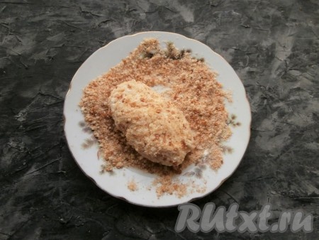 Сформировать сырник с начинкой внутри. Сырнику можно придать круглую или овальную форму - как будет удобно. Таким образом подготовить все сырники и обвалять их в сухарях со всех сторон.

