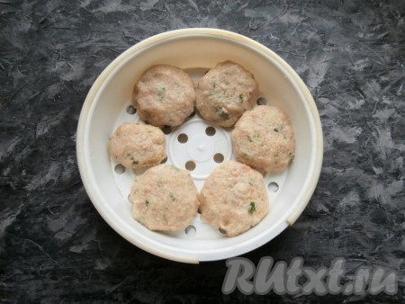 Влажными руками сформировать котлеты и разместить их в чаше мультиварки для варки на пару.
