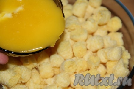 Влить масло в миску с кукурузными палочками.
