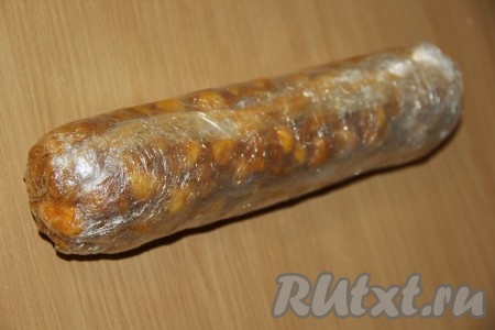 Аккуратно завернуть кукурузные палочки со сгущёнкой в пищевую плёнку, формируя плотную колбаску. Убрать колбаску в холодильник на ночь.
