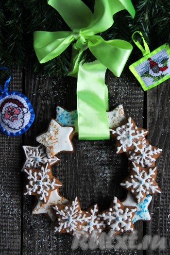 Украсить снежинки глазурью, сразу посыпать кондитерской посыпкой и оставить до полного высыхания глазури (я оставила на сутки). Часть глазури я оставила для склеивания в дальнейшем пряников и отправила в холодильник. Когда глазурь, которой расписаны пряники, застынет, склеить пряники между собой с помощью глазури, которую мы для этого оставляли, формируя венок. Дать нарядному, вкусному рождественскому венку из пряников высохнуть в течение суток. Такая выпечка станет отличным дополнением к праздничному чаепитию. А я сделала несколько веночков, поместила их в красивые коробочки и преподнесла друзьям в подарок.
