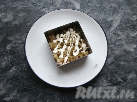 Смазать курицу майонезом. Маринованный огурчик нарезать маленькими кубиками, выложить вторым слоем, тоже смазать майонезом.
