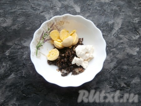 Обжаренные шампиньоны остудить, переложить в миску, добавить майонез. Из половинок яиц вынуть желтки и добавить их к грибам и майонезу.