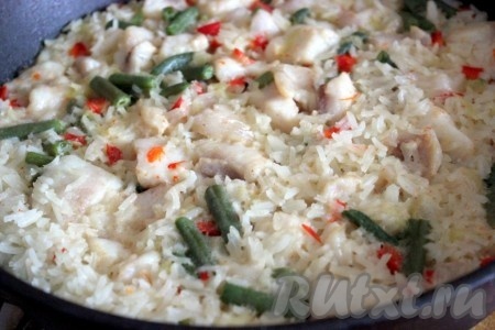 Довести до закипания и тушить рис с рыбой на среднем огне до готовности риса.