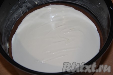 Затем аккуратно с помощью столовой ложки выложить творожную начинку на тесто, начиная с середины. Выкладываем начинку ровным слоем, немного не доходя до краёв теста, формируя тем самым бортик чизкейка (как на фото).
