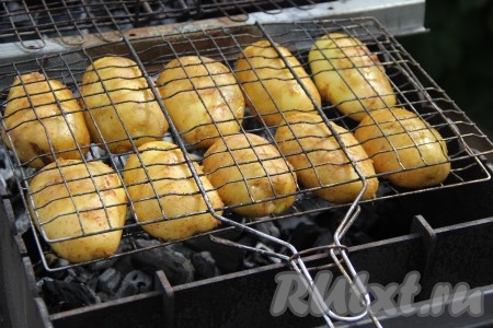 Выложить половинки картошин на решётку и зажать решётку с двух сторон. Мангал предварительно подготовить и разжечь угли. Выложить решётку с картошкой на раскалённые угли без огня. Жар у мангала должен быть хорошим, но без прямого огня.