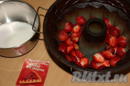 Клубнику очистить от веточек, вымыть, обсушить и разрезать каждую ягоду на две части. Готовить торт лучше в силиконовой форме. Выложить клубнику на дно формы.
