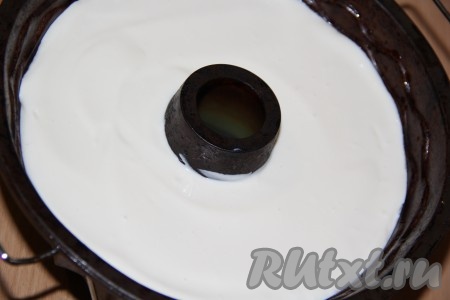 Когда клубника в форме полностью застынет, аккуратно влить в форму творожно-желатиновую массу.
