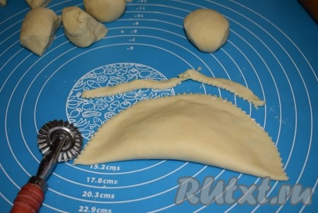 Накрываем начинку свободным краем теста и плотно придавливаем пальцами края, формируя чебурек. Обрезаем край чебурека специальным катком (или краем тарелки).