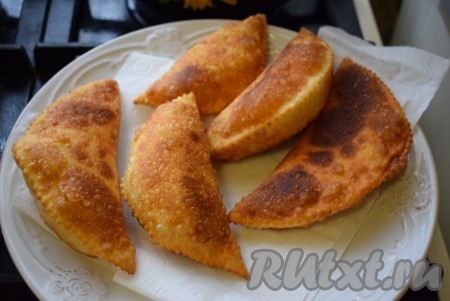 Румяные, аппетитные чебуреки снимаем со сковороды и выкладываем на тарелку, застеленную бумажными полотенцами, для удаления лишнего масла.
