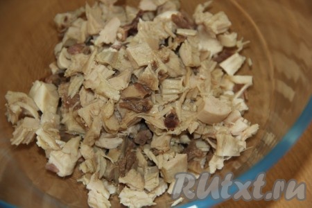 В качестве мясной составляющей для этого салата "Оливье" можно взять варёную колбасу или отварное куриное мясо. Куриное мясо для этого салата можно взять с любых частей курицы (подойдёт, например, филе, куриные бёдра или ножки). Для того чтобы отварить куриное мясо его нужно переложить в кастрюлю, полностью залить водой, а затем поставив на огонь, дать закипеть, снять пенку и варить на небольшом огне в течение 40 минут. Сваренное мясо остудить в бульоне. Отделить мясо от костей и кожи. Нарезать 200 грамм куриного мяса (или колбасы) на небольшие кубики и выложить в миску.