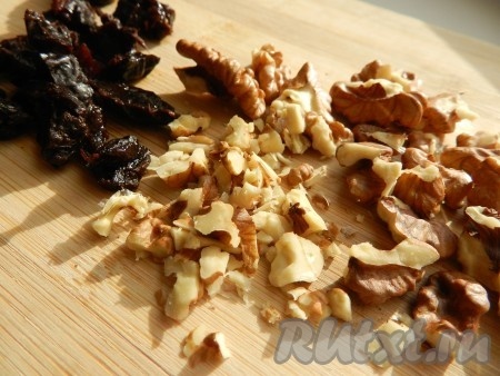 Чернослив промыть горячей водой и нарезать. Орехи очистить и порубить ножом.