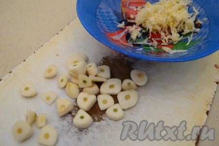 Половину очищенных зубчиков чеснока натрите на средней тёрке. А остальные зубчики нарежьте на пластины, достаточно крупно.
