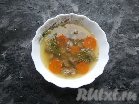 Далее весь оставшийся бульон довести до кипения, снять с огня, добавить желатин и хорошо перемешать. Сердечки разрезать на 2-3 части, разложить их по пиалам (или формочкам), залить бульоном. Украсить кружочками моркови и веточками зелени. Дать бульону остыть до комнатной температуры и отправить пиалы (или формочки) с заливным из куриных сердечек в холодильник на 4-5 часов.
