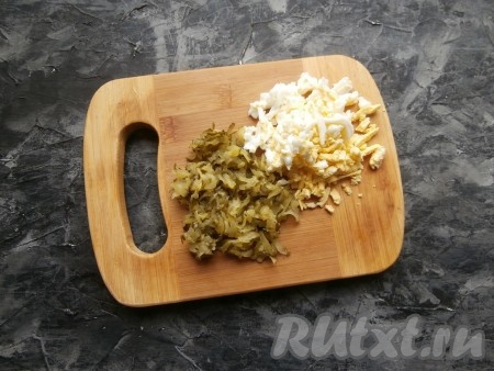 Предварительно сваренное вкрутую (в течение минут 10 с начала кипения воды) и очищенное яйцо, натереть на средней (или крупной) тёрке. Также натереть на тёрке и солёный огурец, хорошенько его отжать от жидкости.
