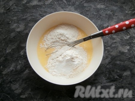 Добавить сливочное масло в молочно-яичную смесь, перемешать венчиком. Затем всыпать муку, соду и разрыхлитель.
