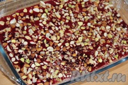 Сверху выложить рубленные орехи. Поставить пастилу из чёрной смородины в таком виде в холодильник на 10 минут.
