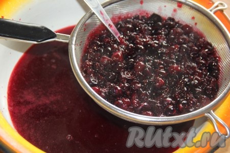 Сито поставить над миской. Ягодную массу из кастрюли откинуть на сито так, чтобы процеженный отвар сливался в миску. Столовой ложкой перетереть ягоды через сито в миску. Жмых, оставшийся в сите, выкинуть.
