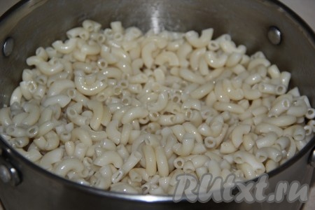 Макароны выложить в кипящую воду, дать закипеть, перемешать, а затем отварить до готовности (обычно на это требуется 7-9 минут, более точное время варки указано на упаковке макаронных изделий, которые вы отвариваете), затем переложить в дуршлаг, промыть холодной водой, отставить в сторону, чтобы стекла вода.
