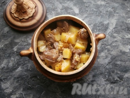 Горшочек с картошкой и бараниной накрыть крышкой и поставить в холодную духовку, выставить температуру 180-190 градусов. Готовить блюдо около 1 часа 30 минут, после чего лавровый лист выбросить, блюдо перемешать.
