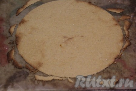 Переложить пергамент (или коврик) с тестом на противень, отправить в разогретую до 180 градусов духовку и выпекать, примерно, 5 минут (до лёгкого золотистого цвета). Горячий корж сразу переложить прямо на пергаменте на стол и обрезать по контуру тарелки.