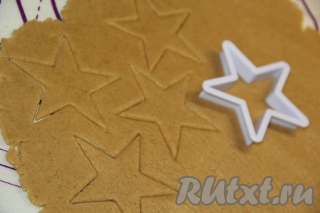 Слегка присыпав поверхность мукой, раскатать тесто с помощью скалки в пласт толщиной, примерно, 0,5 см. Вырезать печенье с помощью формочки "звёздочка".
