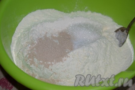 Замесим тесто, для этого в довольно глубокую миску всыпаем муку, соль, сухие дрожжи и сахар, перемешаем столовой ложкой.
