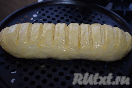 Перекладываем батон на противень, в котором он будет выпекаться, накрываем полотенцем и даём ему подойти, примерно, 35-40 минут. Подошедший батон смазываем при помощи кулинарной кисти взбитым вилкой яйцом.
