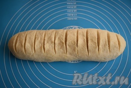 Затем определяемся с тем, каким мы хотим видеть наш будущий батон, и тут у нас есть 2 варианта. Первый вариант: посыпать батон мукой и далее сделать надрезы ножом. И второй вариант: батон надрезать острым ножом и затем перед выпечкой&nbsp;смазать яйцом, тогда он будет иметь глянцевую корочку. Я применила второй вариант.
