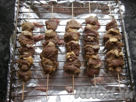 Шпажки с шашлыком из баранины выложить на решётку и отправить в разогретую духовку.
