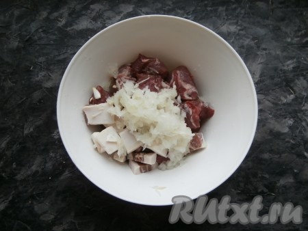 Поместить мясо и кусочки сала в миску, добавить очищенный и натёртый на крупной тёрке репчатый лук.
