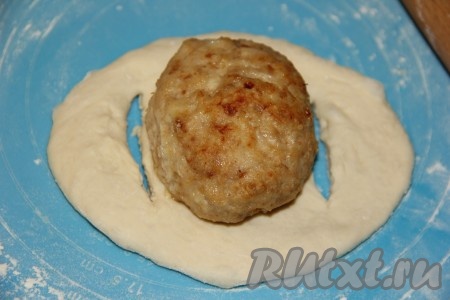 На середину теста выложить котлету.
