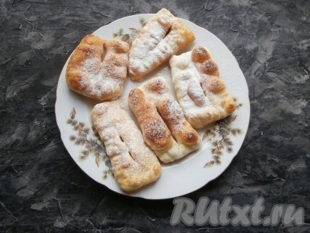 Готовые пышки выкладывать на тарелку, а на сковороде постепенно пожарить все пышечки. Дать им немного остыть, а затем посыпать сахарной пудрой.