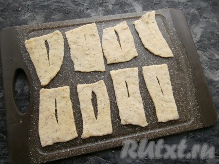 Далее, подсыпая на стол немного муки, раскатать тесто в тонкий пласт (или лепёшку) толщиной 0,4-0,5 см. Нарезать тесто на прямоугольники, квадраты и т.д., в середине сделать разрез.
