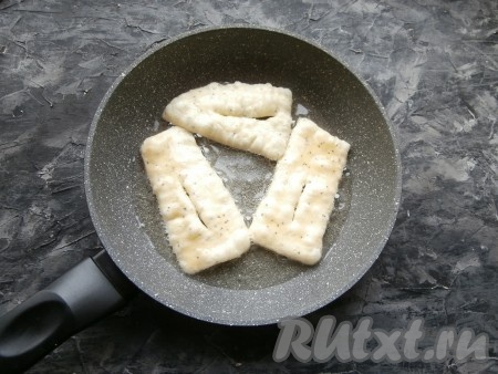 Разогреть в сковороде растительное масло, выложить часть заготовок из теста.
