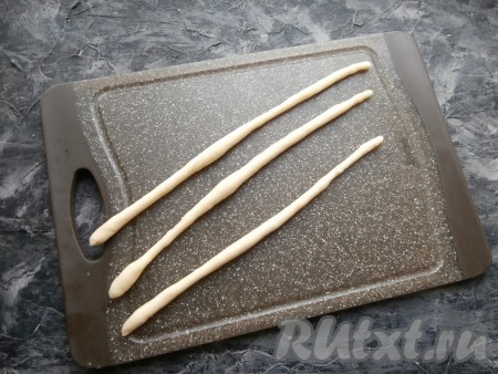 Каждый такой маленький кусочек теста разделить на 3 части и скатать в тонкие жгутики длиной около 23-24 см.
