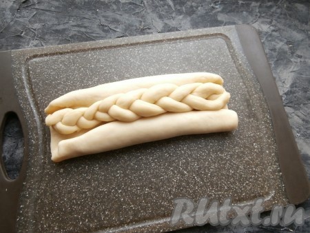 Завернуть лепёшки с верхней и с нижней стороны к центру рулетиками, чтобы варенье оказалось внутри рулетиков. В центр заготовок поместить горизонтально по косичке.
