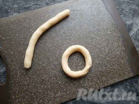 Каждый кусочек теста скатать в жгутик длиной около 15-16 см (тесто довольно рассыпчатое, его нужно греть руками, чтобы получились довольно гладкие жгутики). Свернуть каждый жгутик в кольцо, защипнув вместе края.
