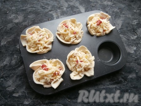 Каждую корзинку из слоёного теста плотно наполнить сырной начинкой, чтобы она была горкой.
