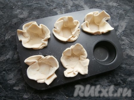 В форму или формочки для кексов поместить квадраты теста, формируя корзиночки. Можно предварительно смазать форму маслом, чтобы выпечка не пристала, я не смазывала, так как использовала форму с антипригарным покрытием.
