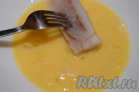 Филе минтая окунуть вначале в яичный кляр, покрывая кусочки рыбы яичной массой со всех сторон.
