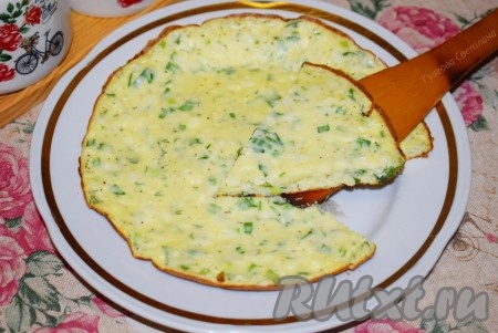 Перекладываем омлет со сковороды на тарелку для подачи и даём ему остыть, примерно, 1-2 минуты, для того чтобы сыр и творог немного застыли.