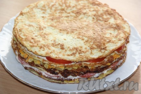 Сверху выложить следующий корж, равномерно разложить на него оставшуюся морковно-луковую массу. Снова накрыть коржом, смазать его майонезом, выложить кружочки помидоров и смазать их немного майонезом, выложить последний корж, его смазывать ничем пока не нужно. В таком виде кабачковый закусочный торт с начинкой из помидоров, сыра, морковки и лука поставить пропитываться в холодильник, как минимум, на пару часов.
