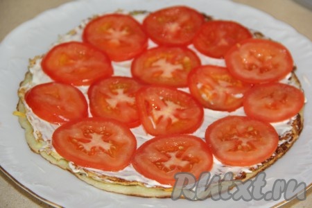 Накрыть вторым коржом. Смазать корж майонезом и выложить тонкие кружочки помидора.
