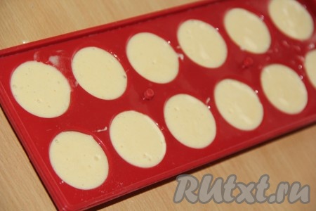 Ячейки силиконовой формы для приготовления кейк-попсов слегка смазать растительным маслом (я смочила ватный диск маслом и протёрла ячейки). Тесто выложить в ту часть силиконовой формы, в которой нет дырочек, полностью заполняя тестом каждую полусферу этой части формы.
