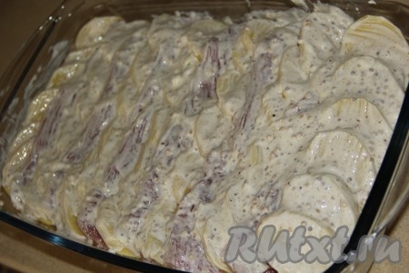 Смазать картошку со свининой получившимся сметанным соусом. Поставить форму с картофелем и мясом в разогретую духовку и запекать 20 минут при температуре 200 градусов.